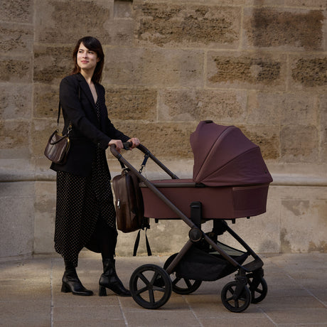 Woman pushing a Venicci Upline 2 Special Edition (SE) Pushchair in Burgundy colour