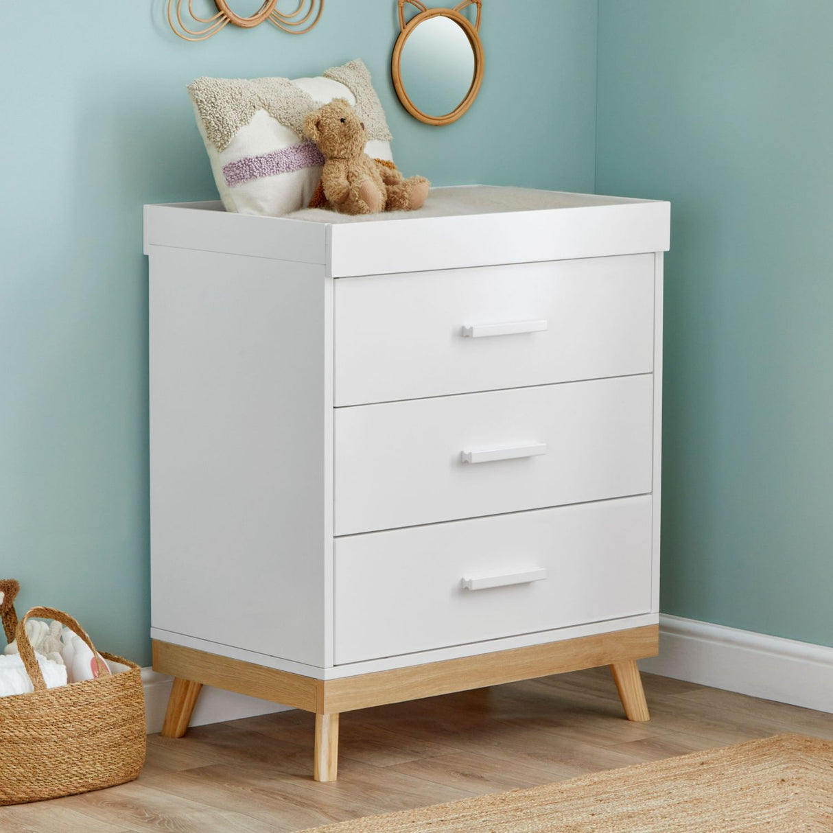 Angled photo of Babymore Mona Nursery Chest Changer in a corner of nursery room with teal-painted walls