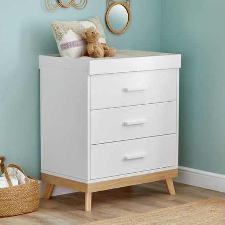 Angled photo of Babymore Mona Nursery Chest Changer in a corner of nursery room with teal-painted walls