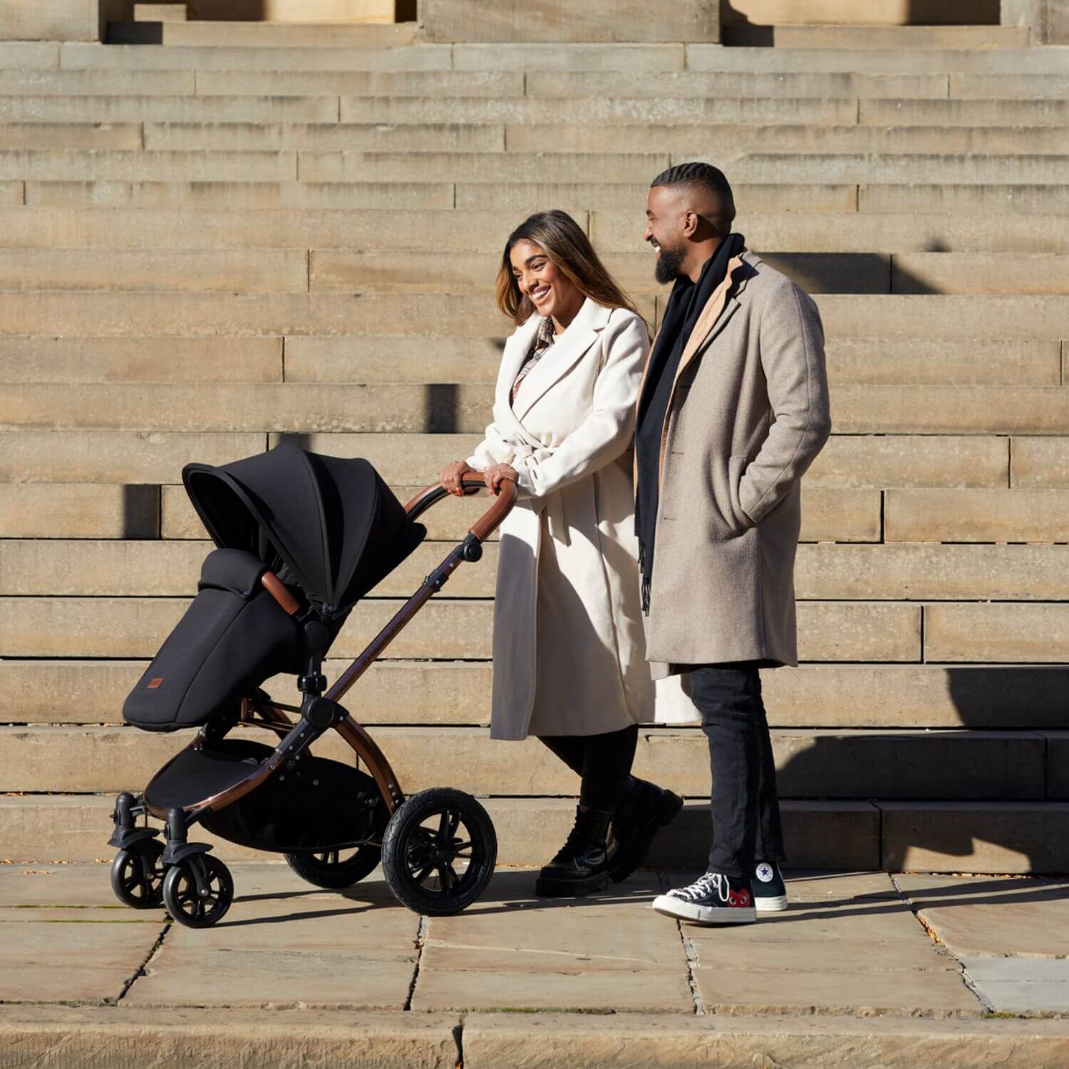 Happy couple pushing the Ickle Bubba Stomp Luxe 9-piece Pram