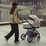 A woman with Woman pushing a Venicci Claro Pram in Vanilla white colour