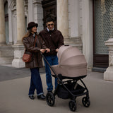 Happy couple pushing a Venicci Claro Pram in Almond colour