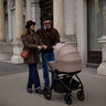 Couple walking while pushing a Venicci Claro Pram in Almond colour