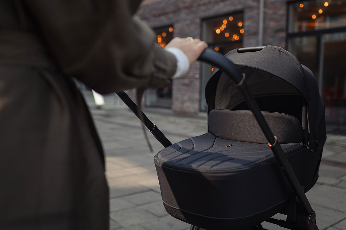 A person pushing a Venicci Claro 2-in-1 Pram in Noir black color